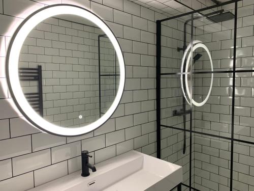 a bathroom with a mirror and a sink at Loft 11 Stunning LUXURY NYC Loft Style Interior Designed 2BD Apartment EXCELLENT CITY CENTRE LOCATION Mezzanine Cinema Room Designer Furniture AMAZING SPACE in Douglas