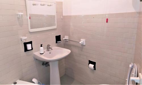 a white bathroom with a sink and a mirror at Il Podestà in Fabriano