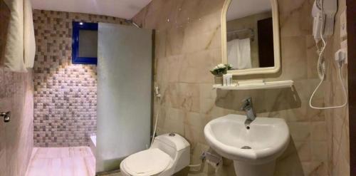 uma casa de banho com um lavatório, um WC e um chuveiro em فندق البروج em Jazan