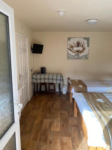 a room with two beds and a table at Clarendon Lodge - accommodation only in Skegness