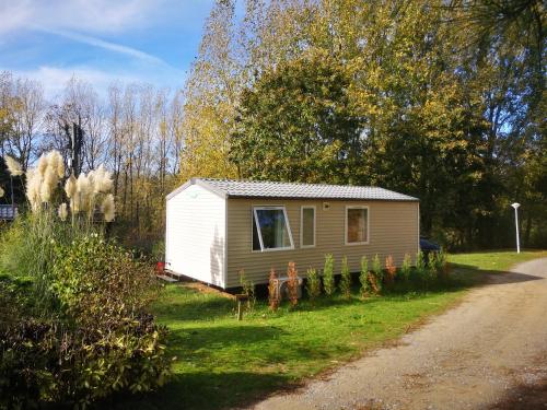 a small house in the grass next to a road at Camping La Dune Blanche - Daly's home in Camiers
