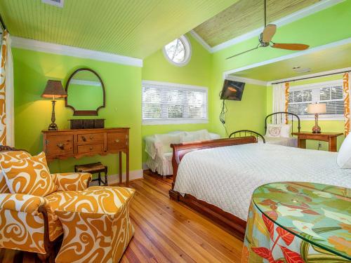 um quarto com paredes verdes, uma cama e um espelho em Blue Skies em Tybee Island