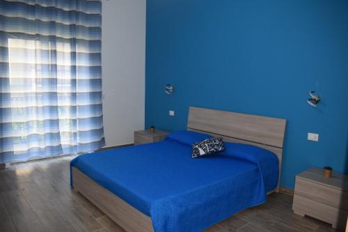 Dormitorio azul con cama y pared azul en Casa Ferrera - Locazione Turistica, en Misterbianco