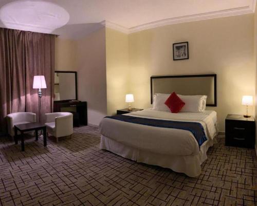 a hotel room with a large bed with a red pillow at فندق البروج الفندقية in Jazan