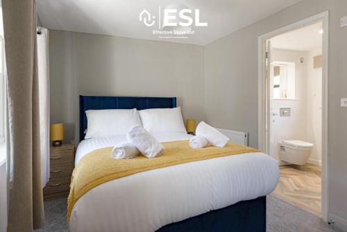 een slaapkamer met een groot bed en handdoeken bij Comfy Modern 2 Bedroom Duplex Apartment with Sun Terrace in Shrewsbury
