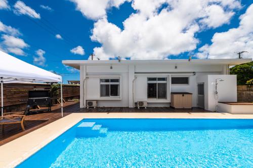 a villa with a swimming pool and a house at Marinus in Miyako-jima