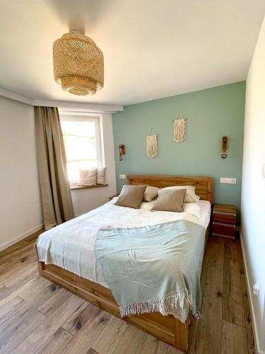 um quarto com uma cama grande e uma parede azul em Sosnowy Apartament em Polanica-Zdrój