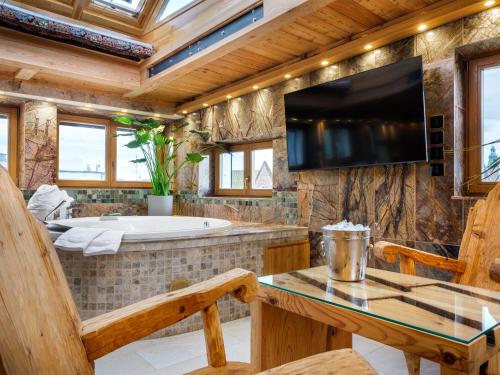a bathroom with a tub and a tv and a table at Aparthotel Stare Miasto in Kraków