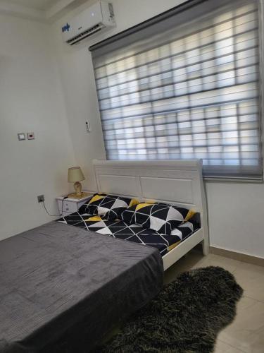 a bedroom with a black and white bed and a window at SUCCESS ROOM Ensuit - East Legon, Adjiringanor in Accra