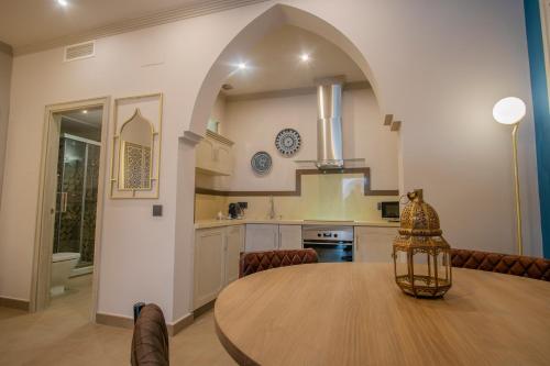 a kitchen and dining room with a wooden table in a room at Apartamentos Turísticos La Baílla in Rota