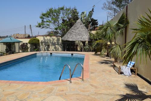 a large swimming pool in a yard with a building at Stasumo House Arusha in Arusha