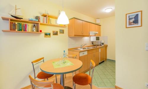 a kitchen with a table and chairs and a sink at Fewo B 34 Am Weststrand Toplage in Kühlungsborn