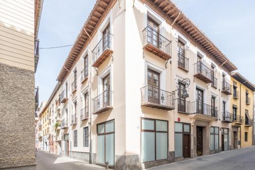 un edificio de apartamentos con balcones en una calle en Apartamentos Luna Suites Palacio Dorita, en Granada