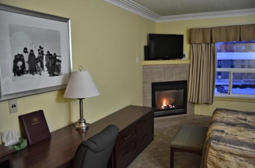 a living room with a fireplace in a hotel room at Nova Inn Inuvik in Inuvik