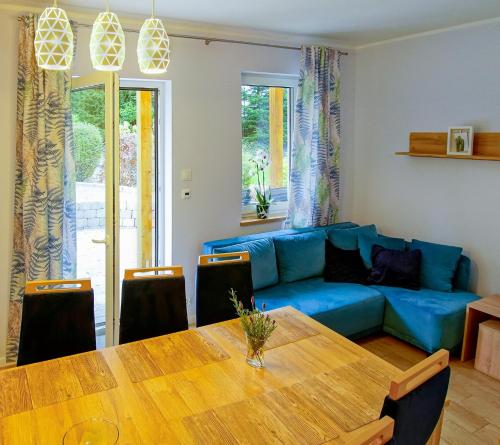 a living room with a blue couch and a wooden table at U Gruszków - domek pod Chojnikiem in Jelenia Góra