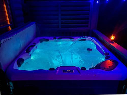 a jacuzzi tub with purple lights in a room at Ryes and Shine Bootlegger's Cabin! Hot Tub* Pool* Arcade* Billiards *EV * Pet Friendly in Sevierville