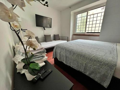 a bedroom with a bed and a couch and a table at Room in Queluz 11 minutes from Lisbon in Queluz