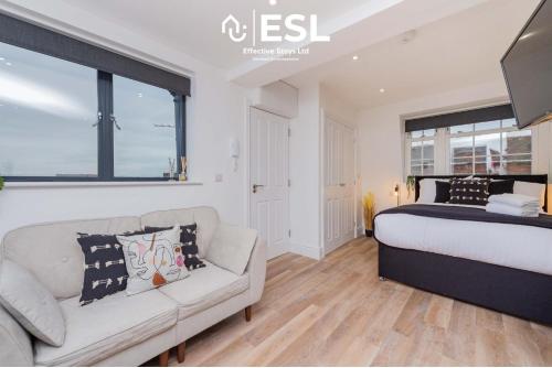 ein Schlafzimmer mit einem Bett und einer Couch in der Unterkunft Studio 3, Top Floor Town Centre Apartment in Shrewsbury