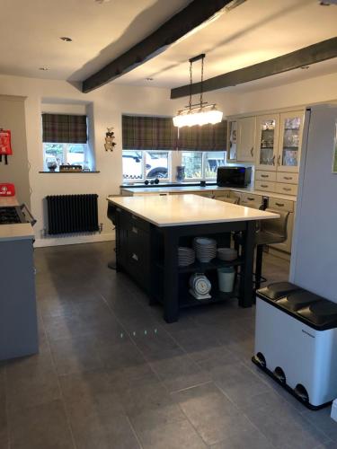 a kitchen with a large island in the middle at Mistletoe Cottage in Foulridge