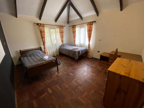 um quarto com duas camas e uma mesa em Agradable departamento - casa con estacionamiento gratis em Sucre