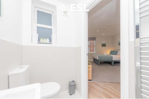 ein weißes Bad mit einem Bett in einem Zimmer in der Unterkunft Studio 2, Second Floor Town Centre Apartment in Shrewsbury