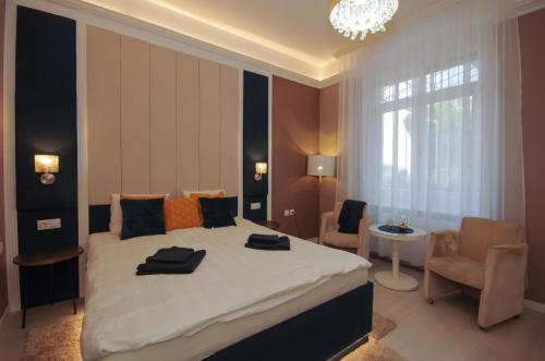 a bedroom with a large bed with two towels on it at Glamour Apartman in Gyula