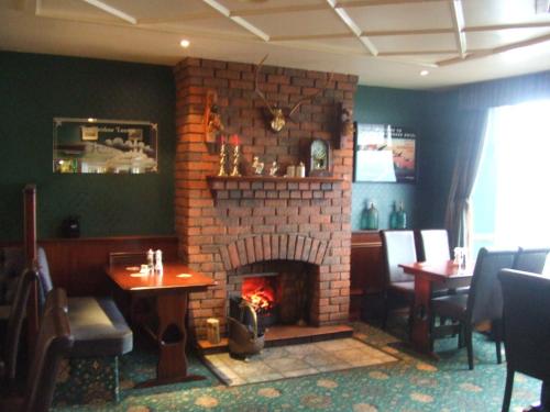 a brick fireplace in a restaurant with a fire place at Halfway House Hotel in Larne