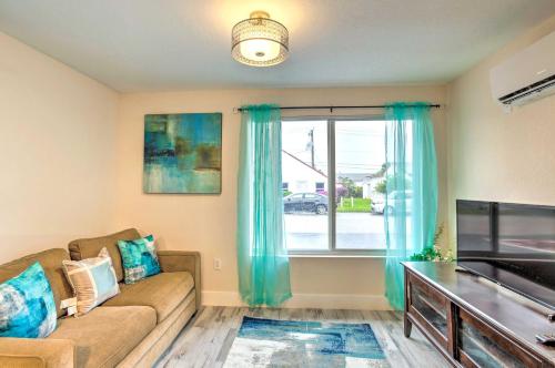a living room with a couch and a large window at Turquoise Escape about 1 Mi to Sailfish Marina! in West Palm Beach