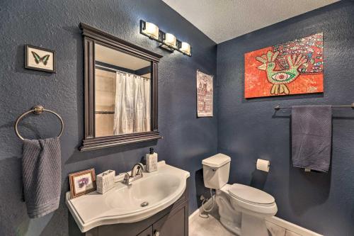 a bathroom with a sink and a toilet and a mirror at Gorgeous Austin Getaway with Fire Pit about 8 Mi to Dtwn in Austin