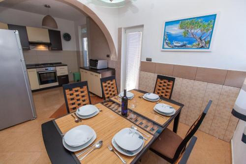 a dining room with a table and chairs and a kitchen at Apartments Loncar in Jadranovo