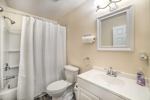 a bathroom with a toilet and a sink and a mirror at Charming Tallahassee Home 1 Mi to Lake Ella! in Tallahassee