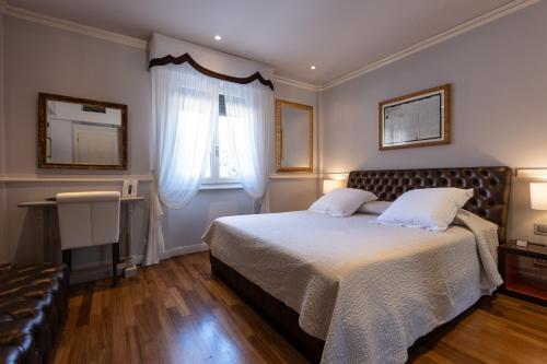 a bedroom with a large bed and a window at Hotel 1908 in Forte dei Marmi