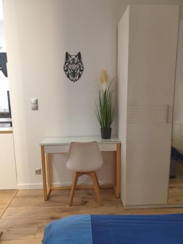 a desk with a chair and a plant on a wall at VILLA MILA Apartamenty in Karpacz