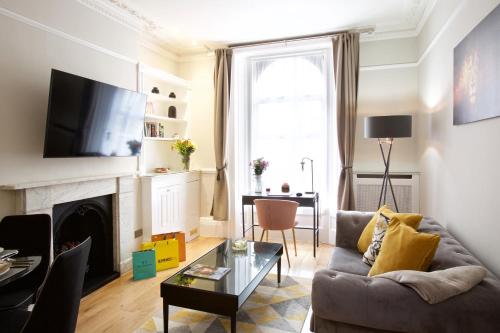 a living room with a couch and a fireplace at Avari Apartments - Winchester Collection in London