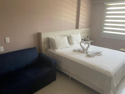 a bedroom with a bed and a blue chair at Estudio Itaipava in Itaipava