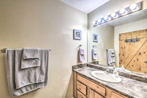 a bathroom with a sink and a wooden door at Updated Ruidoso Cabin with Spacious Deck and View in Ruidoso