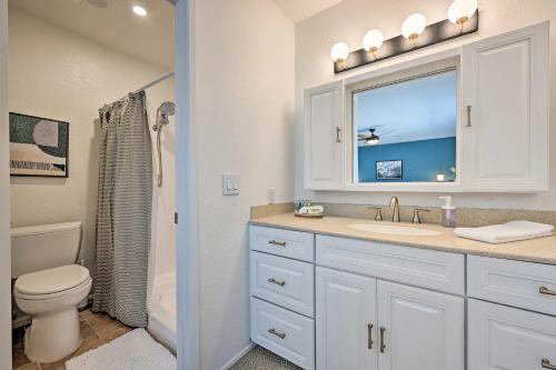 a bathroom with a sink and a toilet and a window at Modern Oceanside Home with Pool and Putting Green in Oceanside