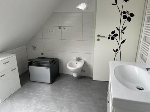 een witte badkamer met een wastafel en een toilet bij Ferienwohnung Wilzenbergblick in Schmallenberg