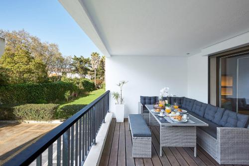 a patio with a table and chairs on a balcony at Oxford Park II in Cascais