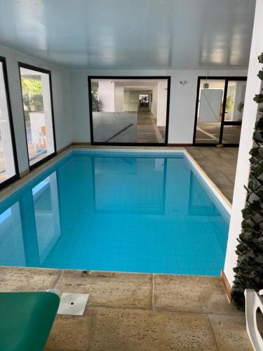 a large swimming pool with blue water in a building at Oxford Park II in Cascais