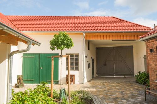 uma garagem com uma porta de garagem verde e um telhado vermelho em Haus Hummel em Lieske