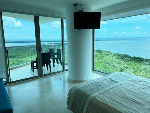 a bedroom with a bed and a view of the ocean at Luxury Apartment in Ocean Pavillion Hotel in Cartagena de Indias