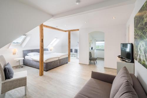 1 dormitorio y sala de estar con 1 cama y TV en Hotel Görtler, en Seesen