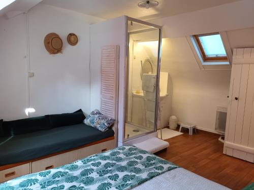 een slaapkamer met een glazen douche en een bed bij La P'tite Normande in Villerville