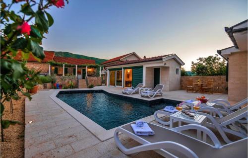 a swimming pool with chairs and a house at Gorgeous Home In Slivno With Sauna in Slivno