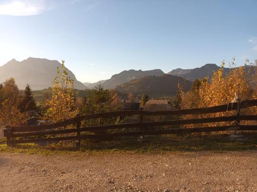 a wooden fence on a dirt road with mountains in the background at Zeit-/Los Quilk in Aigen im Ennstal