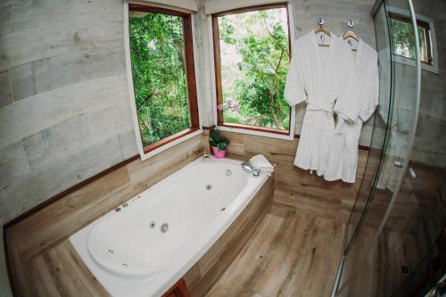 a bathroom with a bath tub and a window at Botánica Iguazú The House Experience in Puerto Iguazú
