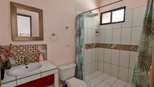 a bathroom with a toilet and a sink and a shower at Nova Beautiful boutique hotel Manuel Antonio in Manuel Antonio