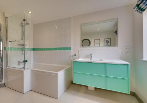 a bathroom with a tub and a sink and a shower at 6 North Green in Southwold