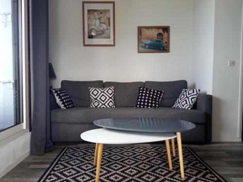 uma sala de estar com um sofá e uma mesa de centro em Appartement 45m2 - Proche Deauville - Vue Mer em Bénerville-sur-Mer